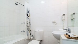 Un baño con bañera, inodoro y lavamanos.