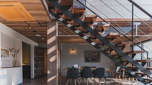 A modern interior with a staircase, dining area, and a large window. - HAOSTAY KAWAGUCHIKO ART MUSEUM. (Fujikawaguchiko)