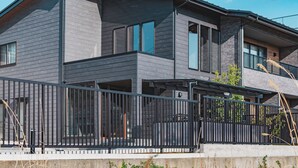 A modern two-story house with a balcony and a black metal fence. - HAOSTAY KAWAGUCHIKO ART MUSEUM. (Fujikawaguchiko)