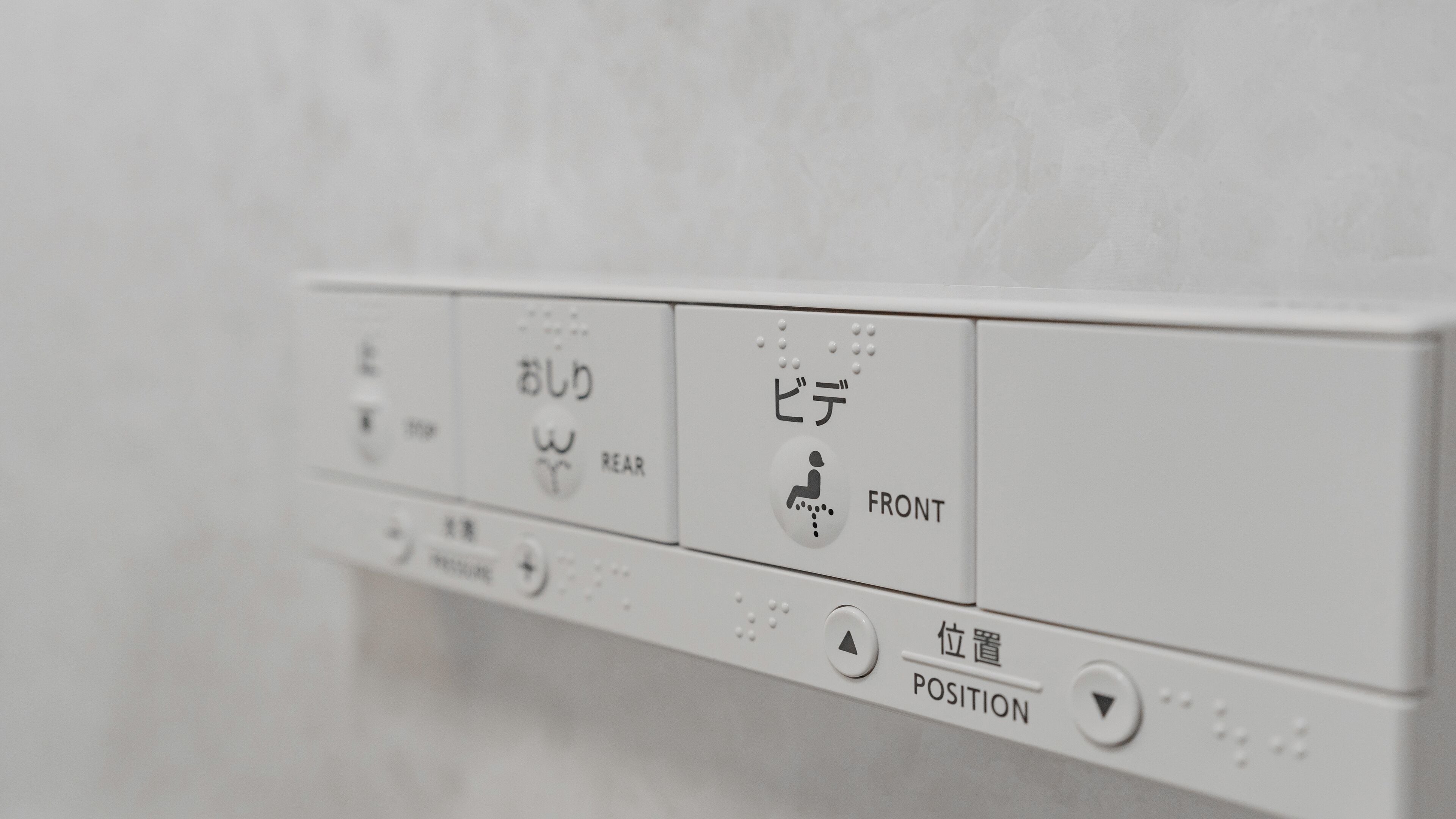 Un panneau de commande avec du texte et des symboles en japonais indiquant les différentes positions pour faciliter l’accès aux fauteuils roulants.