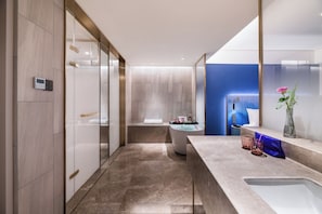 A modern bathroom with a bathtub, a vanity with a mirror, and a shower area.