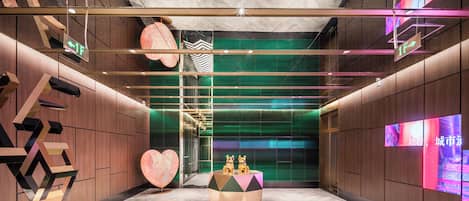 A modern interior with geometric wall designs, a central decorative table, and directional signage.