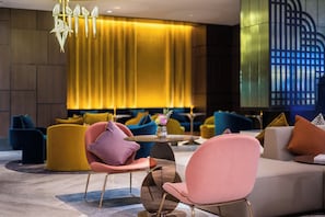 A modern lobby with a round table, plush seating, and a large curtain. - Manxin Hotel Jingzhong Yuci Longhu (Jinzhong)