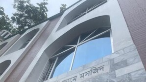 A building entrance with a large arched window and a sign in a foreign language. - Rainagar rajbari (Sylhet)