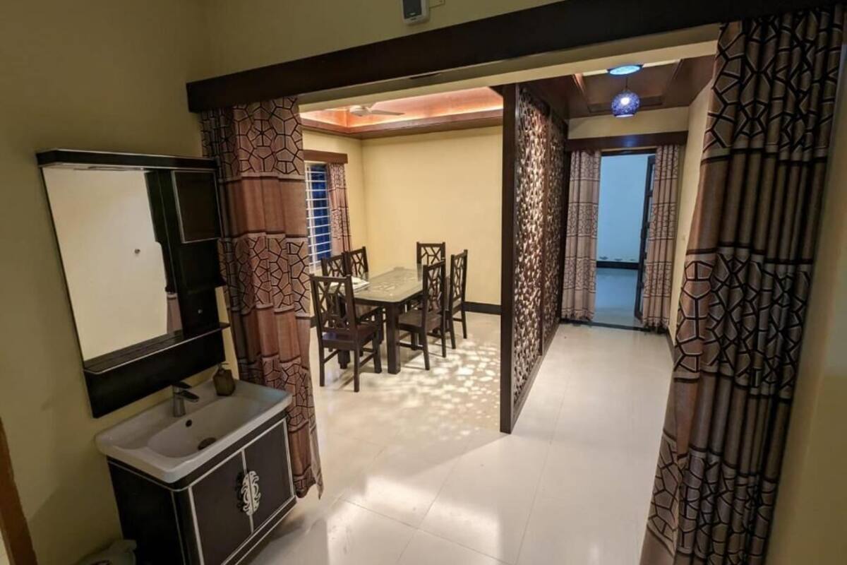 Una habitación con una mesa de comedor, sillas, un televisor y un armario.
