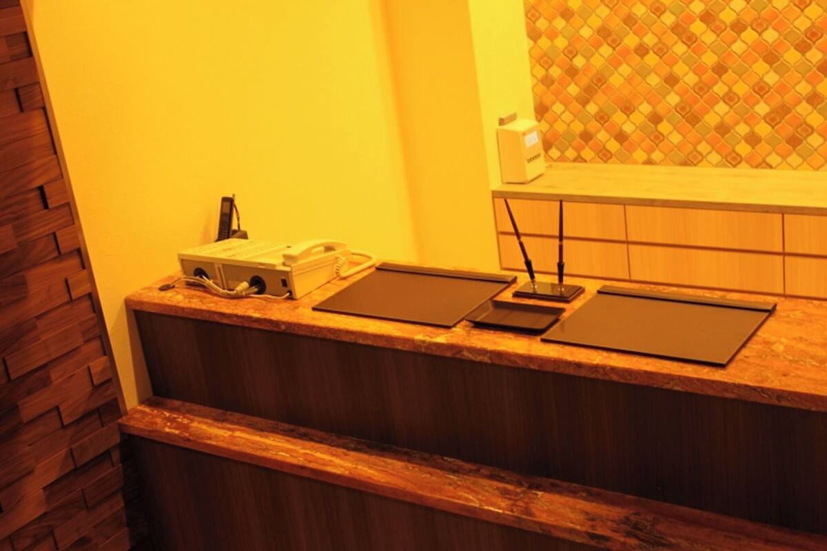 A reception desk with a telephone, a box, and a tablet.