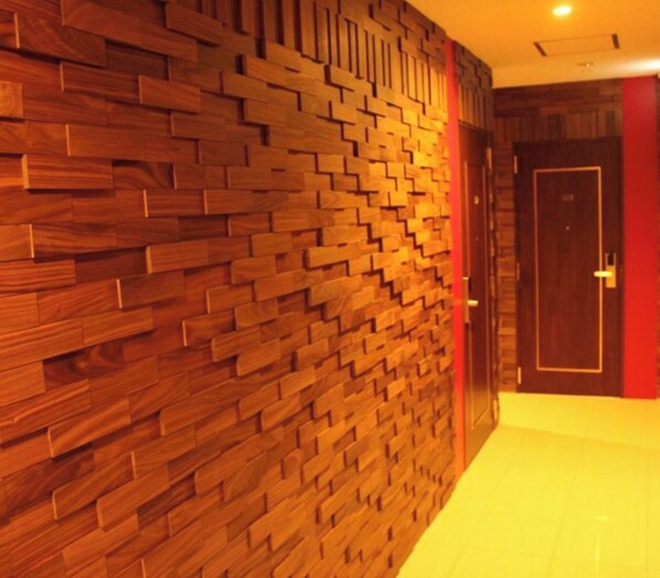 A hallway with a wooden wall and a door. - Hotel Boti Boti (Osaka)