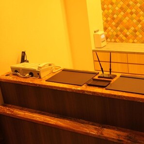 A reception desk with a telephone, a small box, and a tablet.