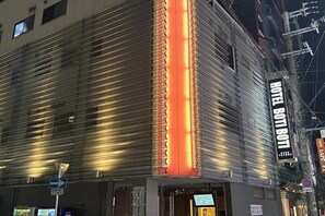 A hotel facade with a prominent vertical sign and a clear entrance.