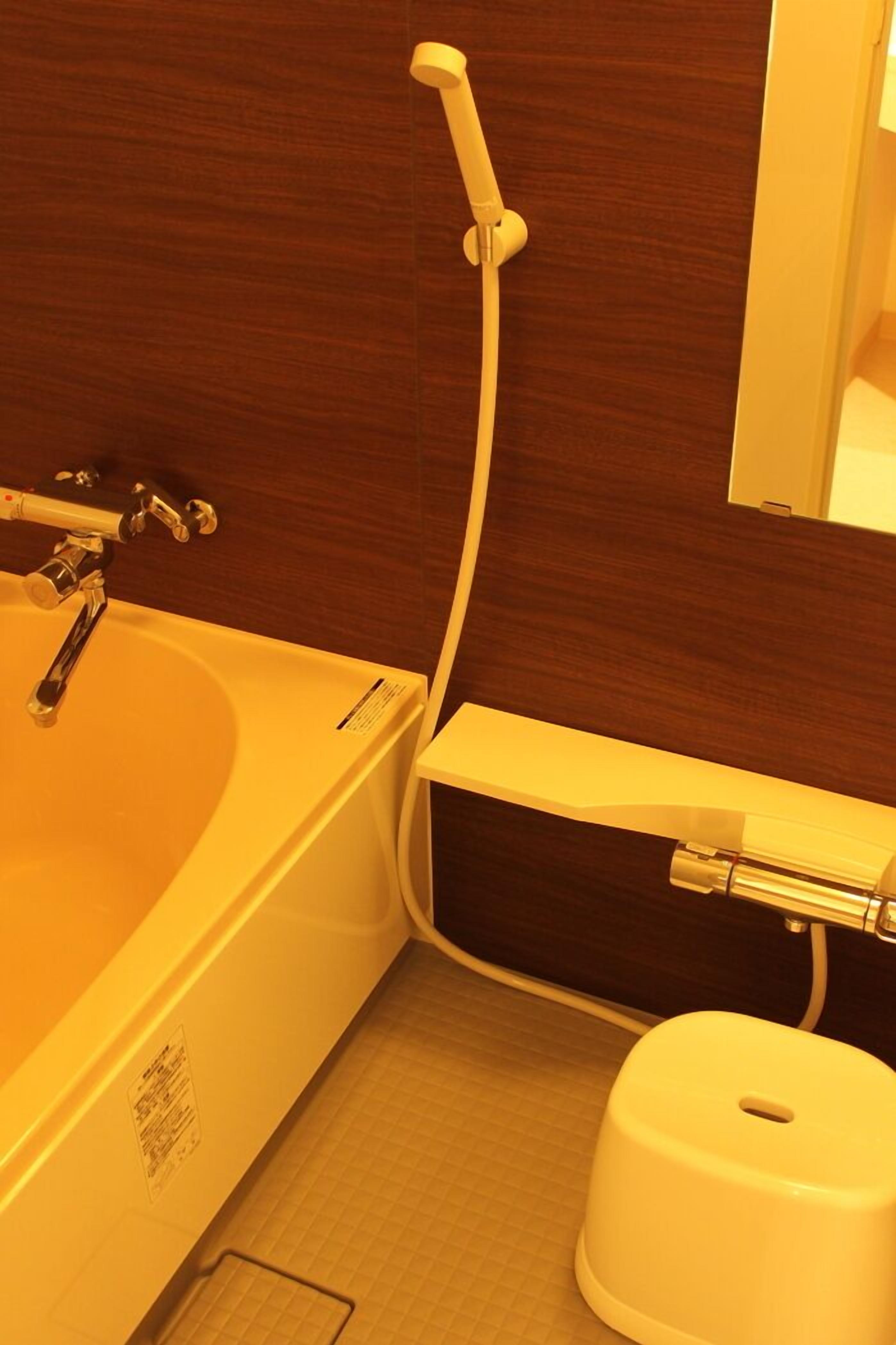 A bathroom with a bathtub, a toilet, and a shower.