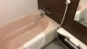 A modern bathroom with a beige bathtub, a white towel, a glass shower enclosure, and a wooden wall. - Hotel Boti Boti (Osaka)