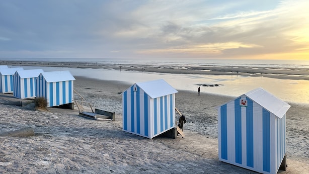Cabañas de playa con vista al mar y al atardecer.