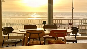 Un comedor con vista al océano al atardecer.