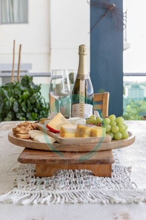 A table with a cheese board, a bottle of wine, and a glass of wine.