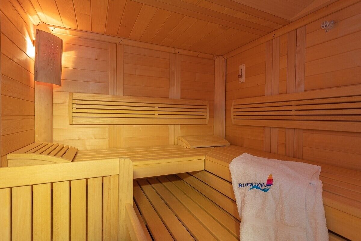 Un sauna de madera con bancos y un perchero para toallas.