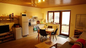 A compact living space with a kitchenette, dining area, and a sofa.