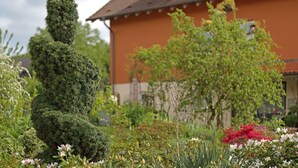 A topiary sculpture in a garden with a house in the background.