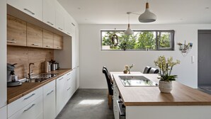 Una cocina moderna con armarios de madera, una isla central y un ventanal grande.