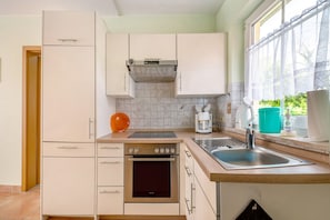 A kitchen with a built-in oven, a coffee maker, and a sink.