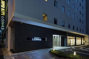 A hotel entrance with a sign reading 'LOHAS' and a parking area. - Super Hotel Premier Hakataeki (Fukuoka)