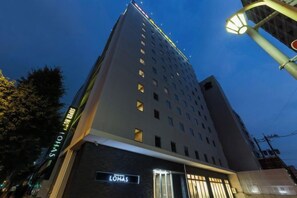 A multi-story hotel with a modern design, featuring a prominent sign for 'LOHAS' and a visible entrance.