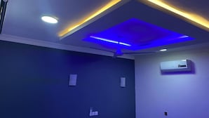 A room with a recessed ceiling, an air conditioning unit on the wall, and a ceiling fan. - Fully Furnished Studio Apartment (Tema West Municipal)