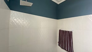 A bathroom with a shower, a towel rack, and patterned tiles. - Fully Furnished Studio Apartment (Tema West Municipal)