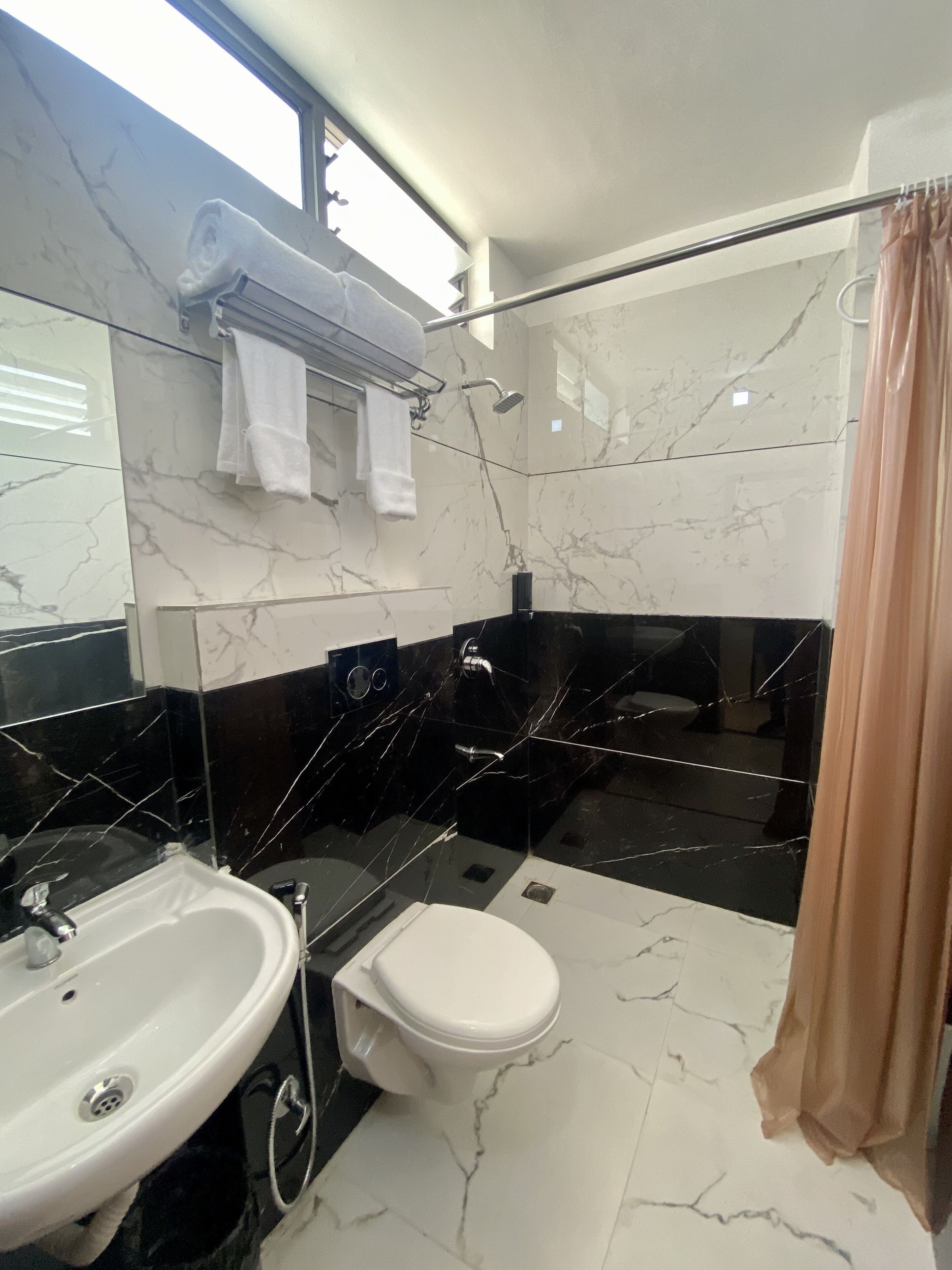 A modern bathroom with a sink, toilet, and shower.