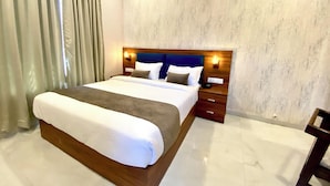 Une chambre d’hôtel moderne avec un grand lit, une t ête de lit en bois et un mur décoré d’un motif imitant le marbre.