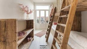 A compact room with a bunk bed, wooden shelves, and a small rug. - Casa Diva – renovated house for 12 in Blankenberge (Blankenberge)