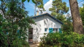 A small, white house with a sloped roof, surrounded by dense greenery and trees. - Villa L'Herbaudière - La Baule les Pins (La Baule-Escoublac)