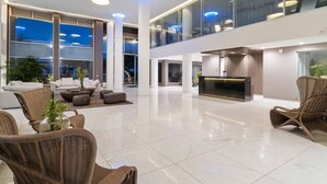 A spacious lobby with high ceilings, a reception desk, and comfortable seating areas.