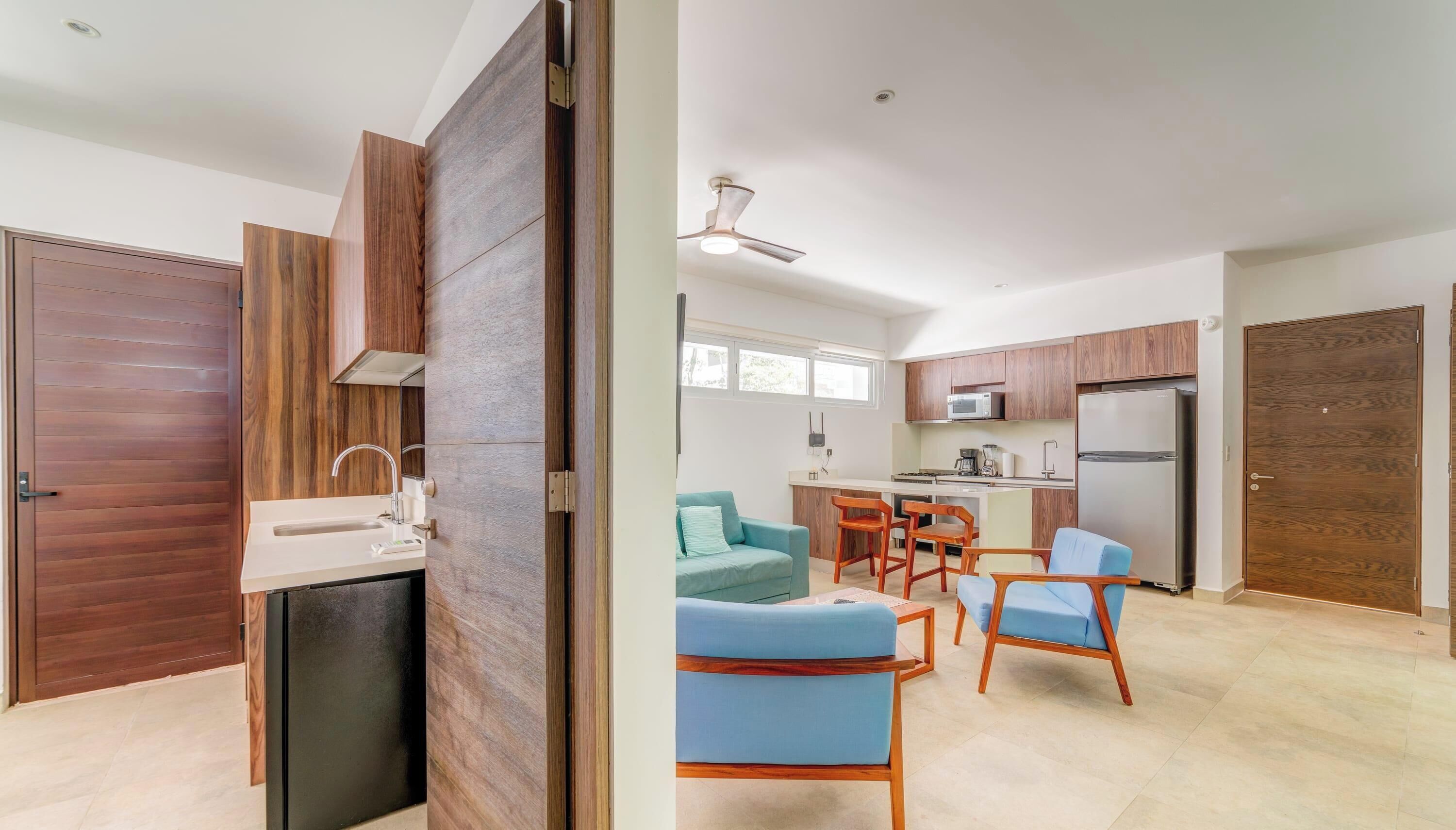 A modern kitchen with wooden cabinets, a built-in microwave, and a refrigerator.