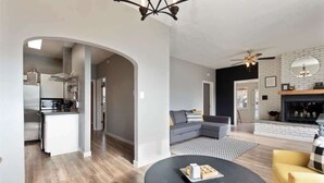 Ein modernes Wohnzimmer mit Kamin, einem runden Couchtisch und einer Couch.