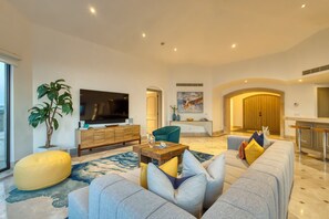 A modern living room with a sofa set, a coffee table, a television, and a plant. - Casa Dos Soles | 3 Bed, 3 Bath (Cabo San Lucas)