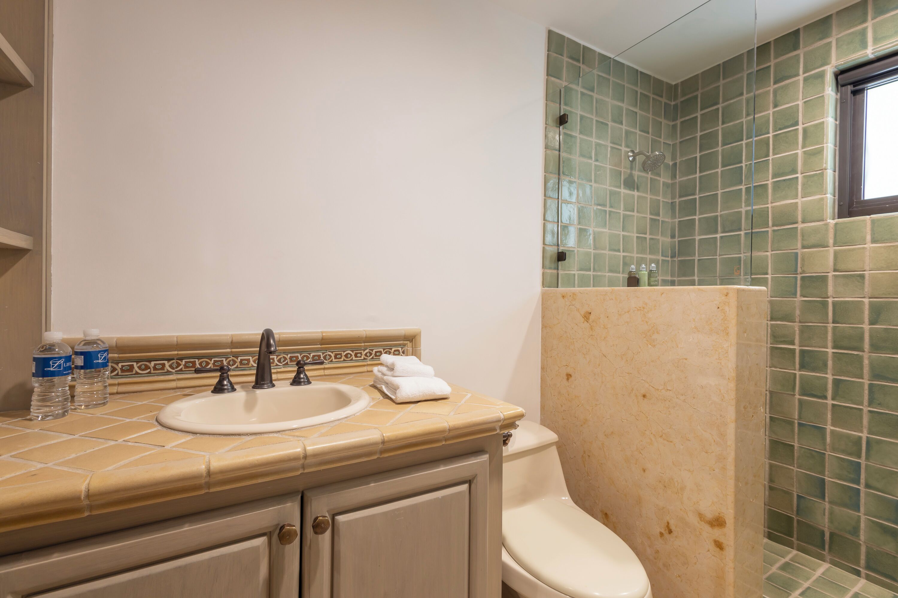 A bathroom with a sink, toilet, and shower.