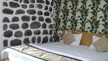A bed with a white and beige bedspread, a wooden headboard, and a ceiling fan.