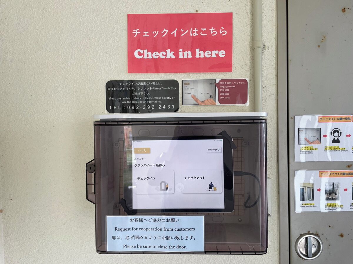 A security kiosk with a sign instructing to check in here.