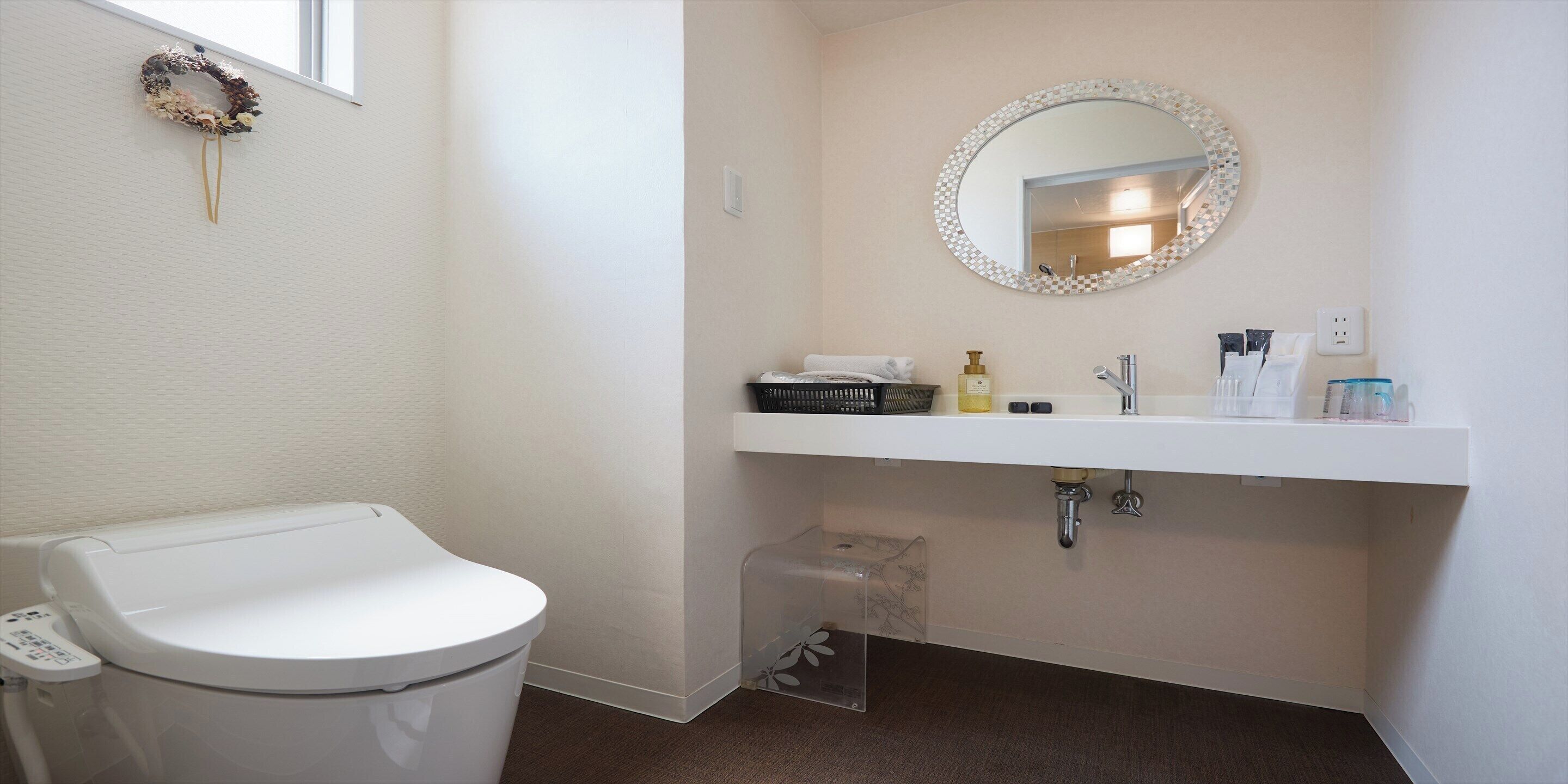 Een badkamer met toilet, wastafel en spiegel.