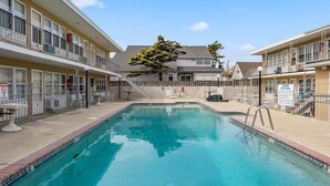 A swimming pool with a no diving sign, a notice about pool rules, and a tree in the background. - Sun, Sand &Poolside Fun! Beautiful 1BR Beach Condo (North Wildwood)