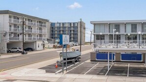 A multi-story building with balconies, a parking lot, and a boat dock. - Sun, Sand &Poolside Fun! Beautiful 1BR Beach Condo (North Wildwood)