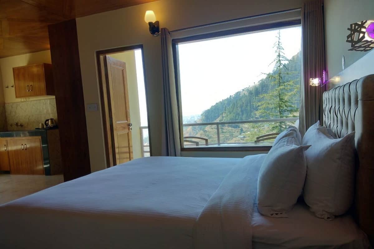 Ein Schlafzimmer mit einem großen Bett, Bergblick und Holzbalkendecke.