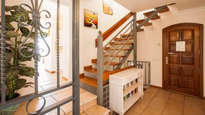 A staircase with wooden steps and metal railings, a white console table, and a wooden door.