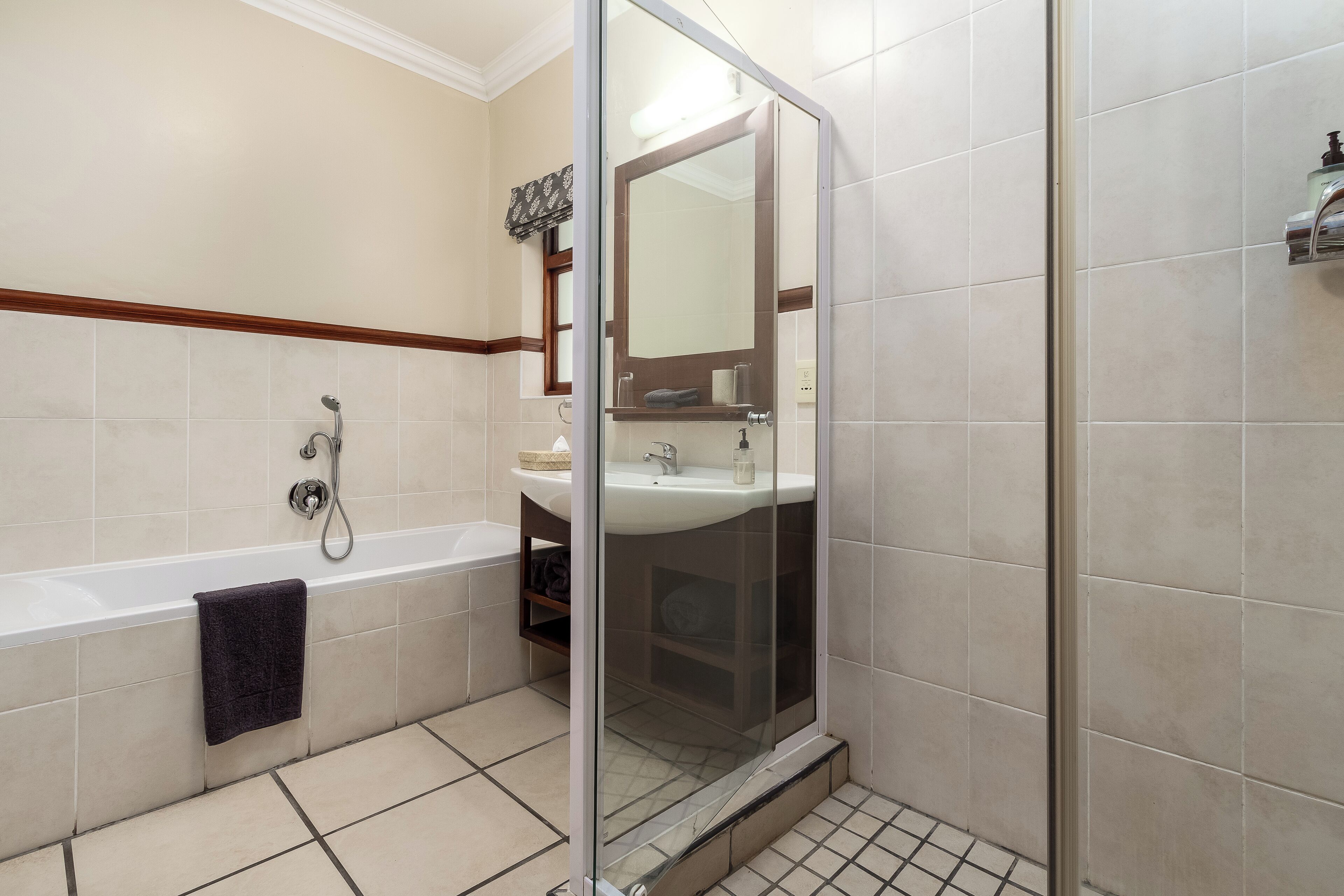 Une salle de bain avec une douche à parois de verre, une baignoire et un lavabo.