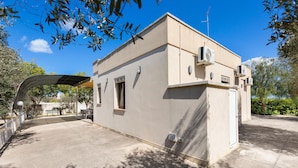A small, single-story building with a flat roof, air conditioning units, and a covered outdoor area with a curved roof. - 3846 Villetta Le Largure A by Barbarhouse (Melendugno)