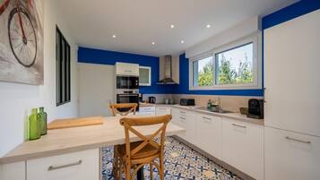 Een koffiezetapparaat/waterkoker, kookgerei, borden en bestek