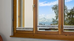 A room with a window overlooking a mountainous landscape. - Ambassador II n°10 - 4 pers - près des pistes (Haute-Nendaz)