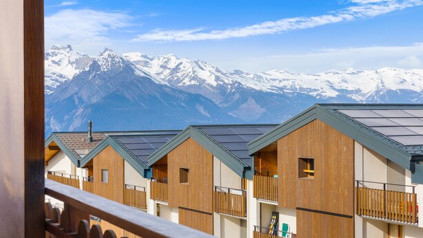 A row of wooden cabins with a mountain backdrop. - Ambassador II n°10 - 4 pers - près des pistes (Haute-Nendaz)