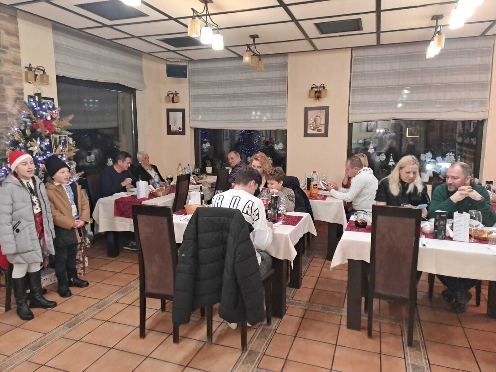 Un restaurante con varias mesas y sillas, suelo de baldosas e iluminación empotrada en el techo.