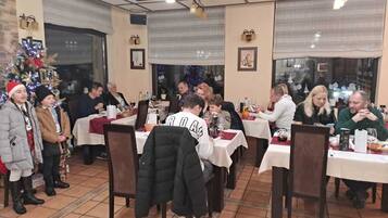 Un restaurante con varias mesas y sillas, suelo de baldosas e iluminación empotrada en el techo.
